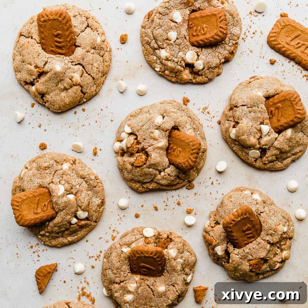 Delicious Crumbl Biscoff White Chip Cookies, showcasing their unique texture and delightful flavors from Biscoff crumbs, cookie butter, and white chocolate chips, against a warm tan background.