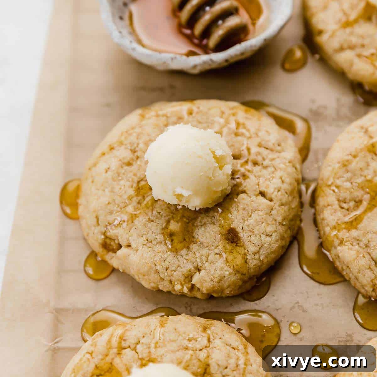 A delectable Crumbl Cornbread Cookie, warmly drizzled with honey and crowned with a melting butter ball, highlighting its comforting flavors.