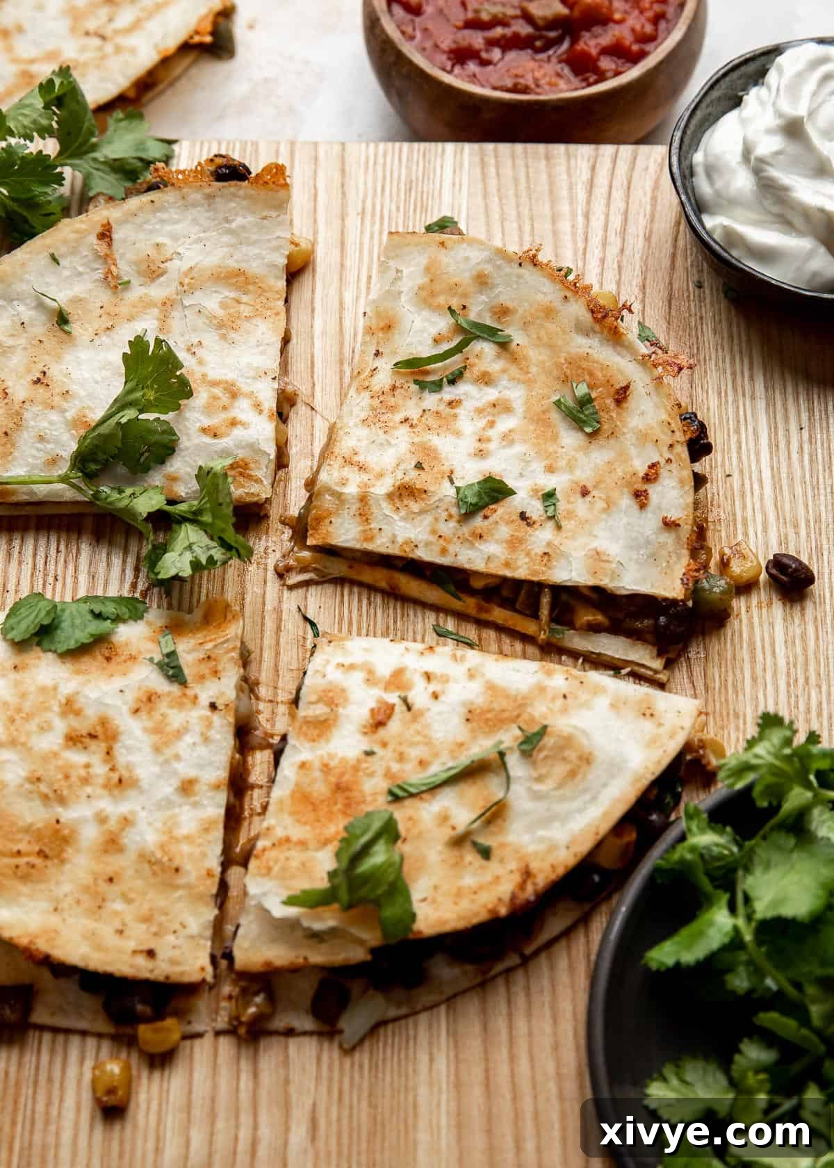 A perfectly cooked Black Bean and Corn Quesadilla, golden brown and sliced into wedges, garnished with fresh cilantro, ready to be served.
