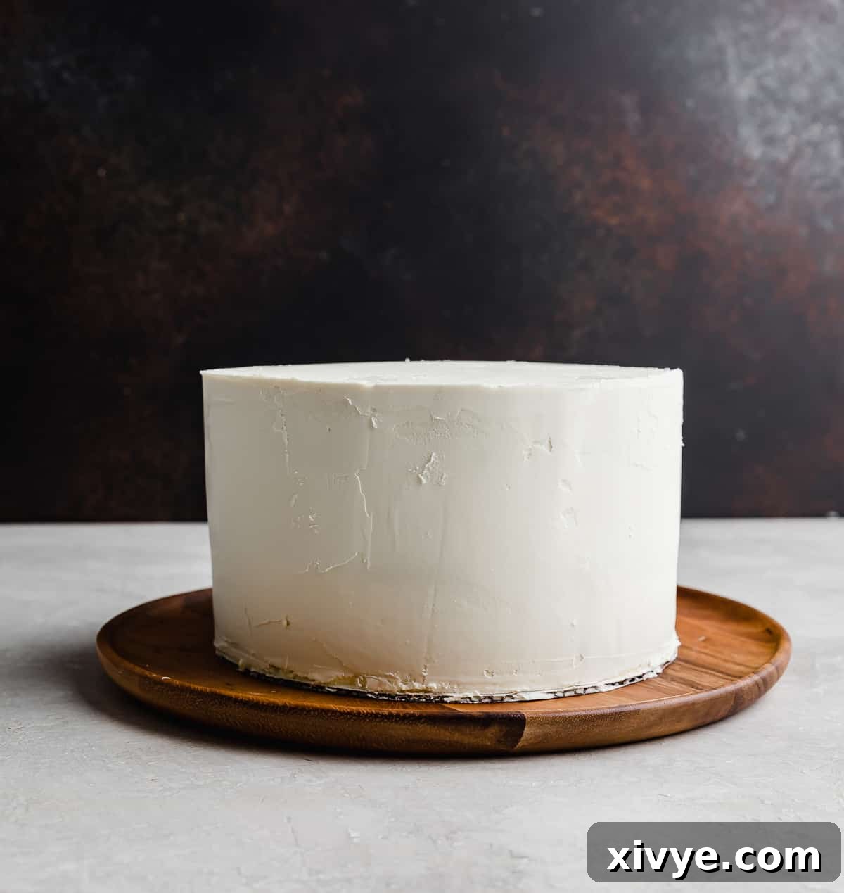 A white chocolate ganache covered round 3 tier layer cake, a true culinary masterpiece.