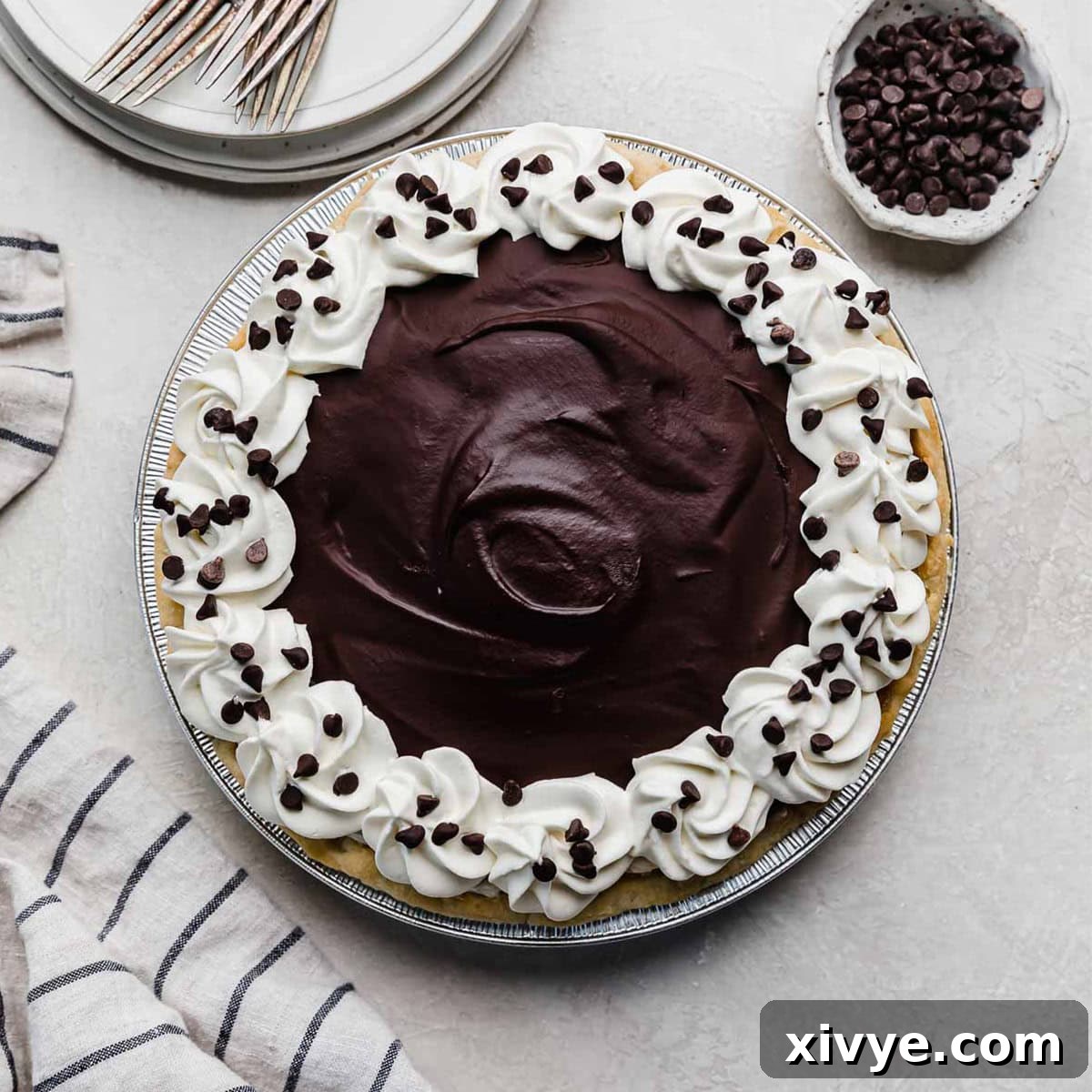 Butter pie crust filled with no bake cannoli pie filling and topped with chocolate ganache and whipped topping and mini chocolate chips.
