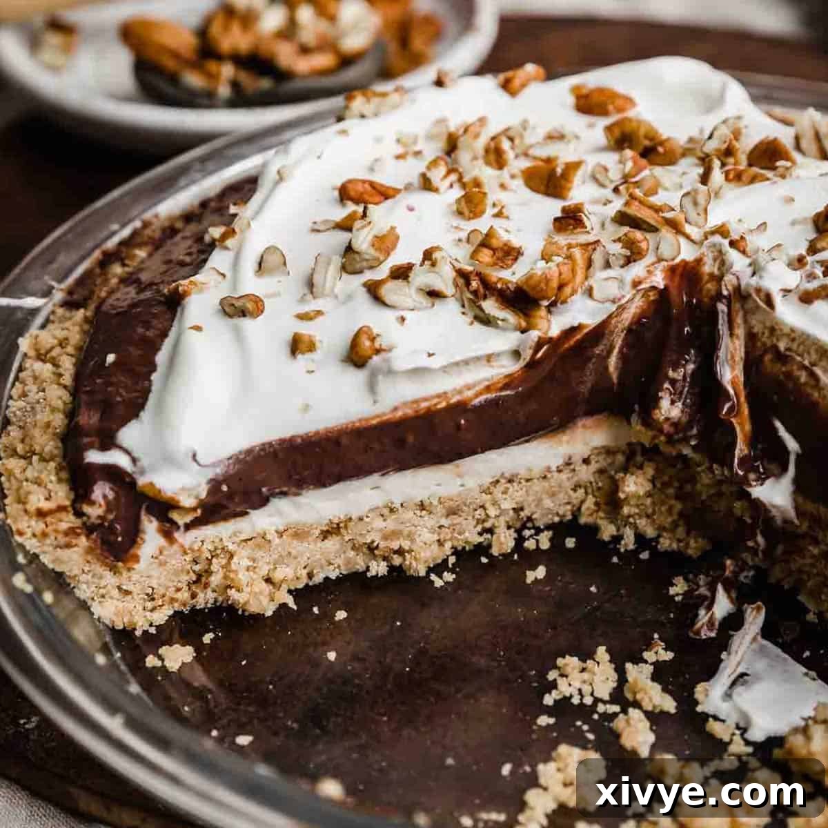 An Arkansas Possum pie sliced into, showing the pecan shortbread crust, cream cheese layer, chocolate pudding layer, and whipped topping layers.