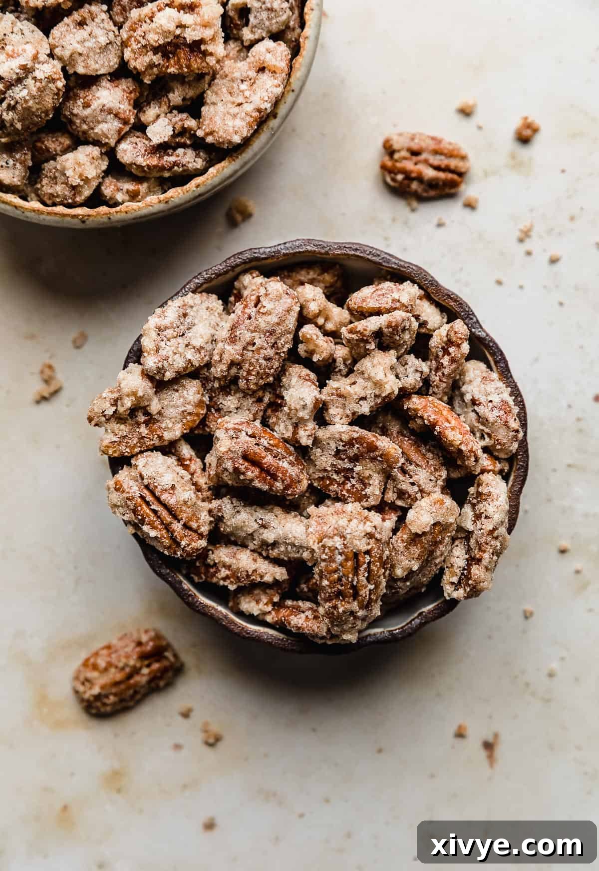 Sweet Glazed Pecans 12 Two bowls overflowing with glistening sugared candied pecans, ready to be enjoyed as a sweet treat.