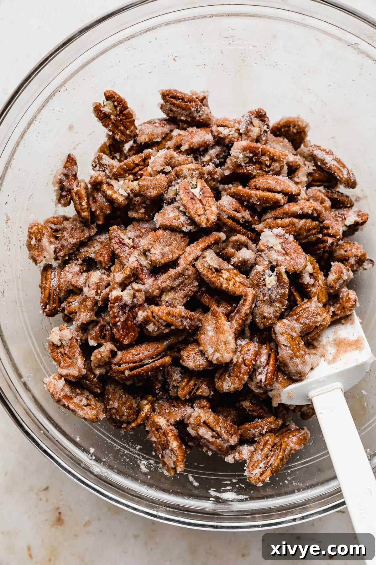 Sweet Glazed Pecans 8 Cinnamon sugar coated pecans in a glass bowl, showing the nuts evenly covered in the spice mixture.
