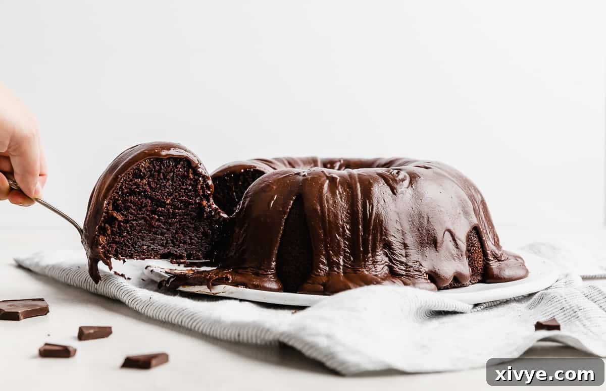 A slice of chocolate Bundt Cake being removed from the full cake.