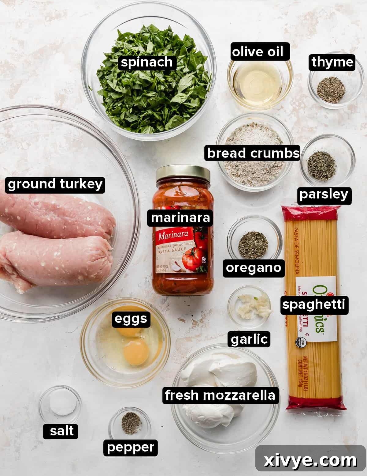 Ingredients used to make Turkey Spinach Meatballs and Spaghetti portioned into glass bowls and elegantly arranged on a clean white background.
