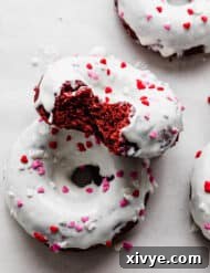 White chocolate topped red velvet donuts with festive Valentine's Day sprinkles.