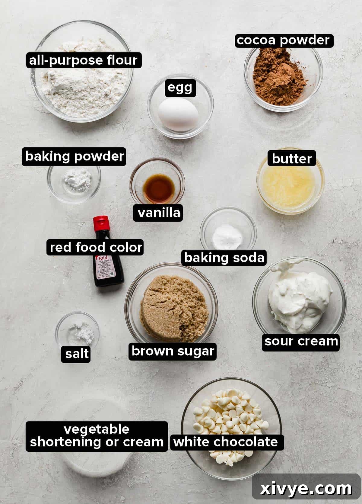 Velvet Dream Doughnuts 3 All the essential ingredients for making Red Velvet Donuts, perfectly portioned into elegant glass bowls, arranged on a light gray background.