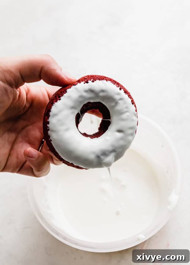 Velvet Dream Doughnuts 9 A freshly baked Red Velvet Donut, elegantly dipped and coated in a smooth white chocolate glaze, ready for garnish.
