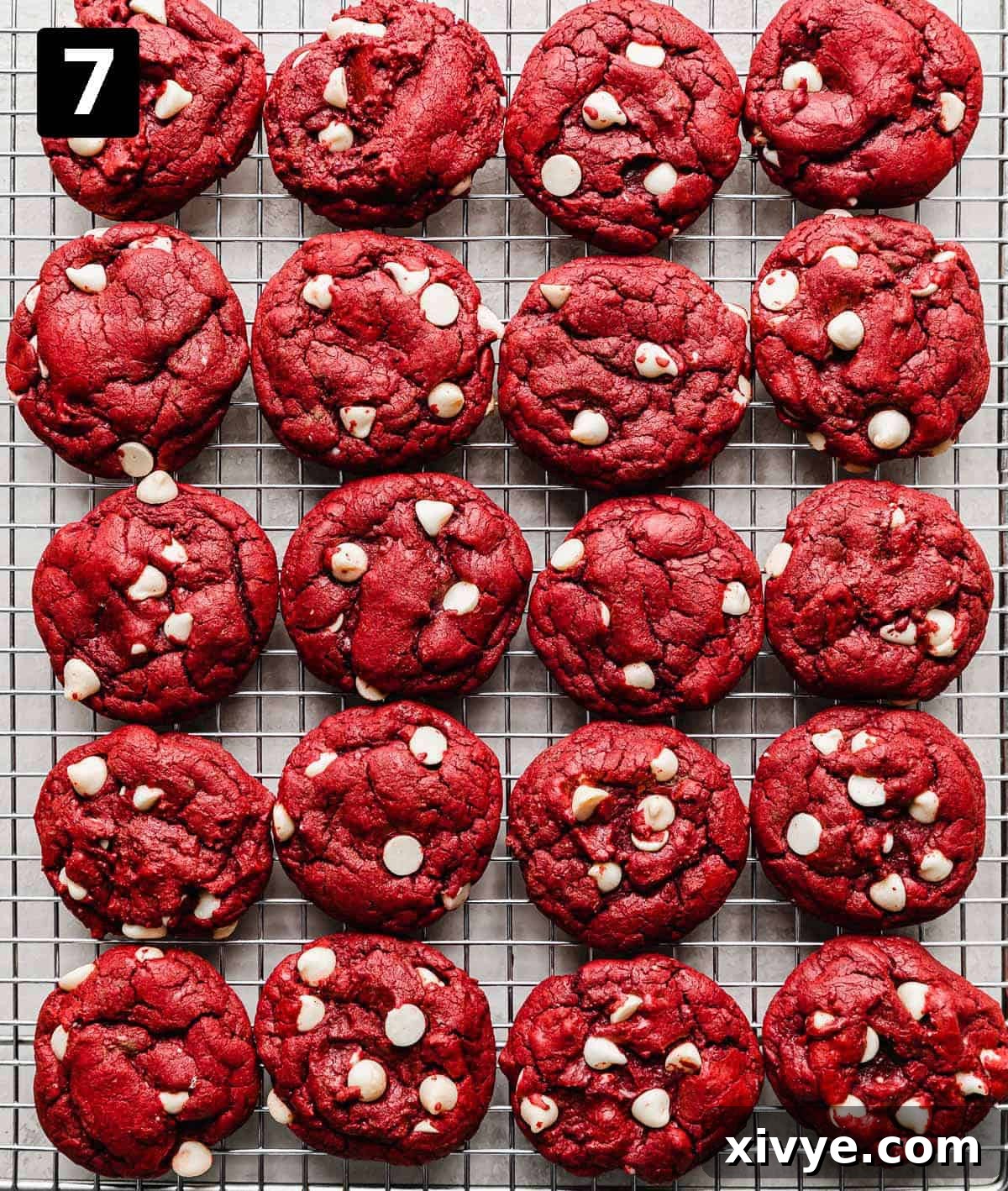 Red Velvet Cake Cookies 6 Red Velvet Cake Mix Cookies with white chocolate chips lined up on a wire cooling rack.