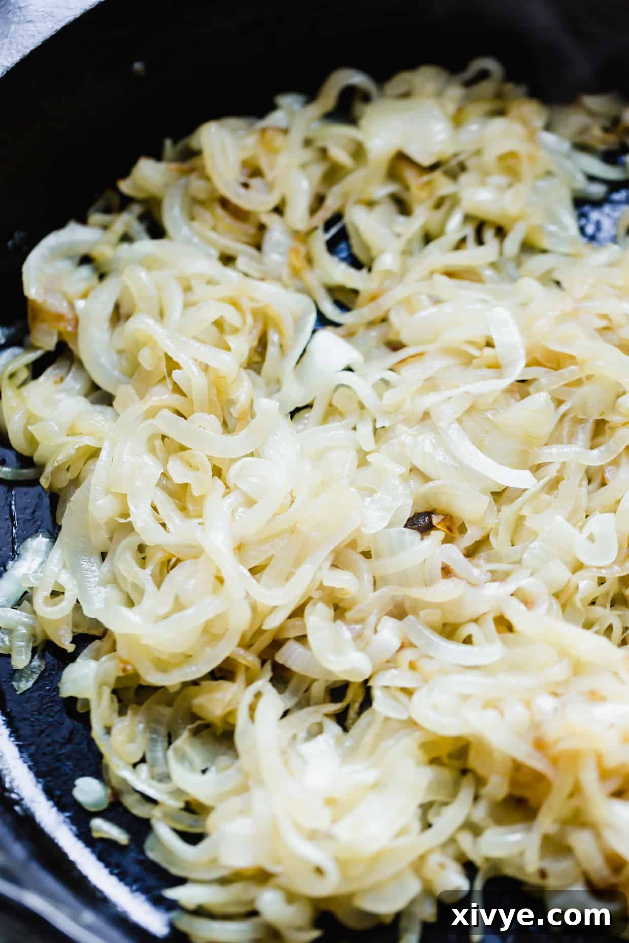 Velvety Onion Cream Cheese Dip 4 Partially caramelized onions in a black skillet.