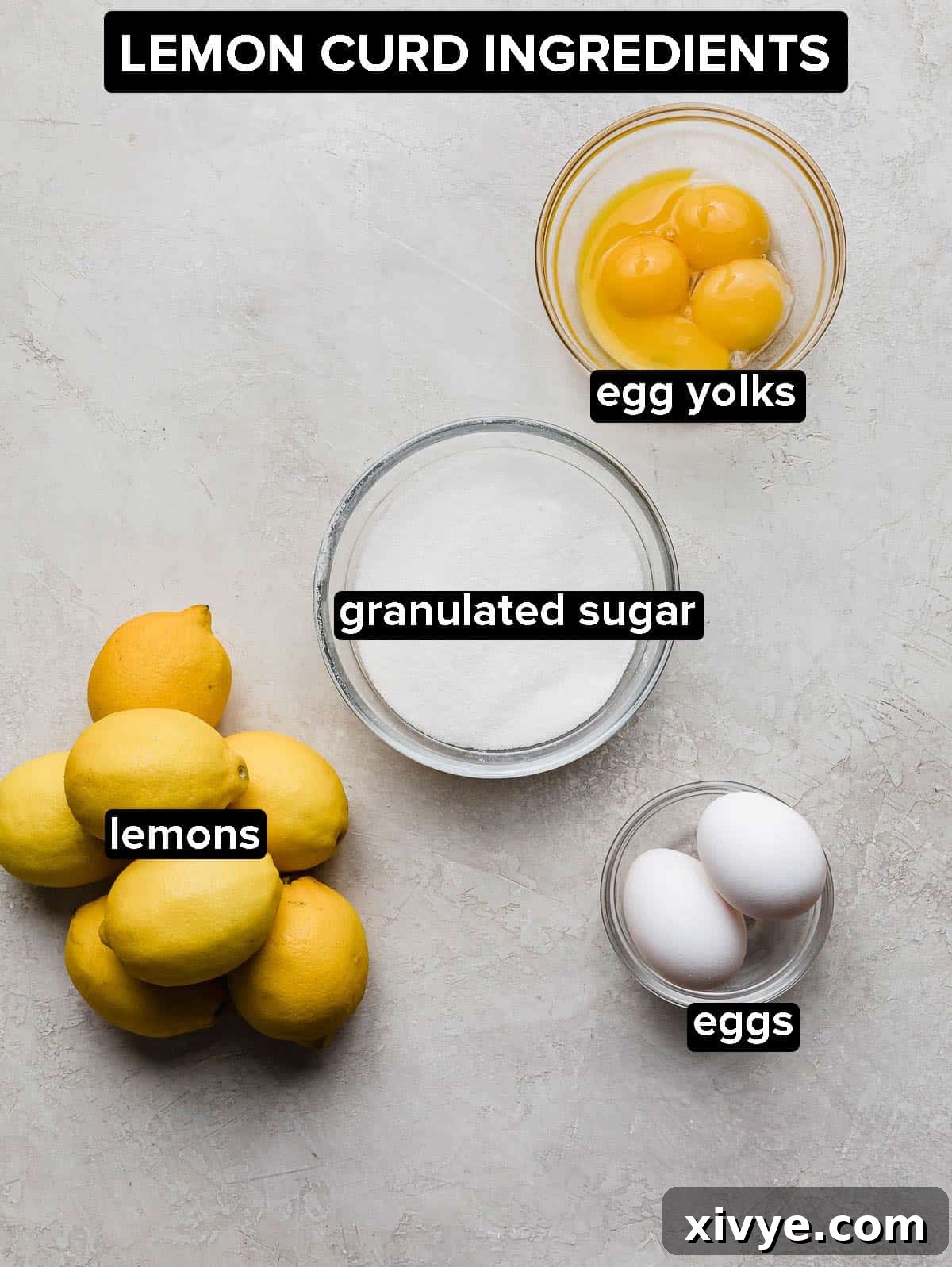 Lemon curd ingredients in glass bowls on a light grey background, showing eggs, sugar, lemon juice, and zest.