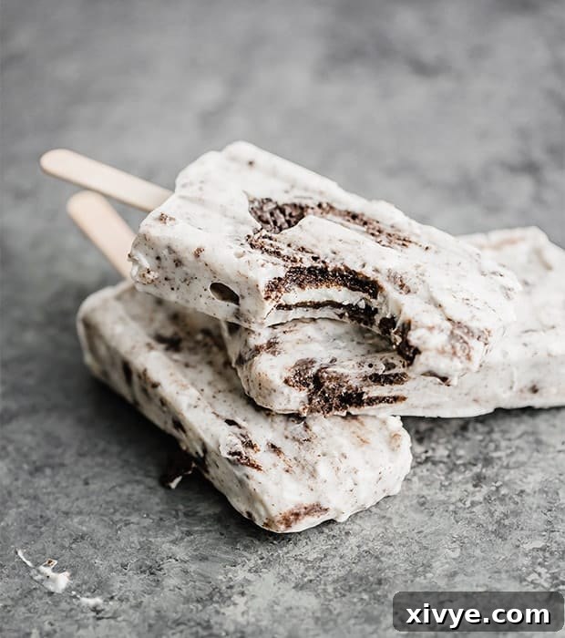 Irresistible Oreo Creations 26 Three perfectly stacked cookies and cream popsicles, with a delightful bite taken out of the top one, ready to be enjoyed.