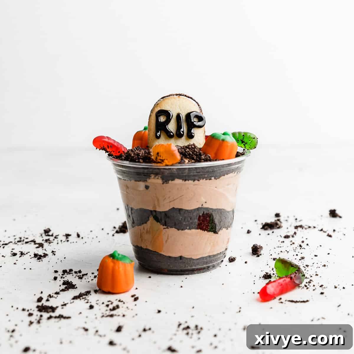 Irresistible Oreo Creations 28 A festive Halloween Dirt Cup, whimsically decorated with gummy worms and cookie crumbs, set against a clean white background, ready for a spooky treat.