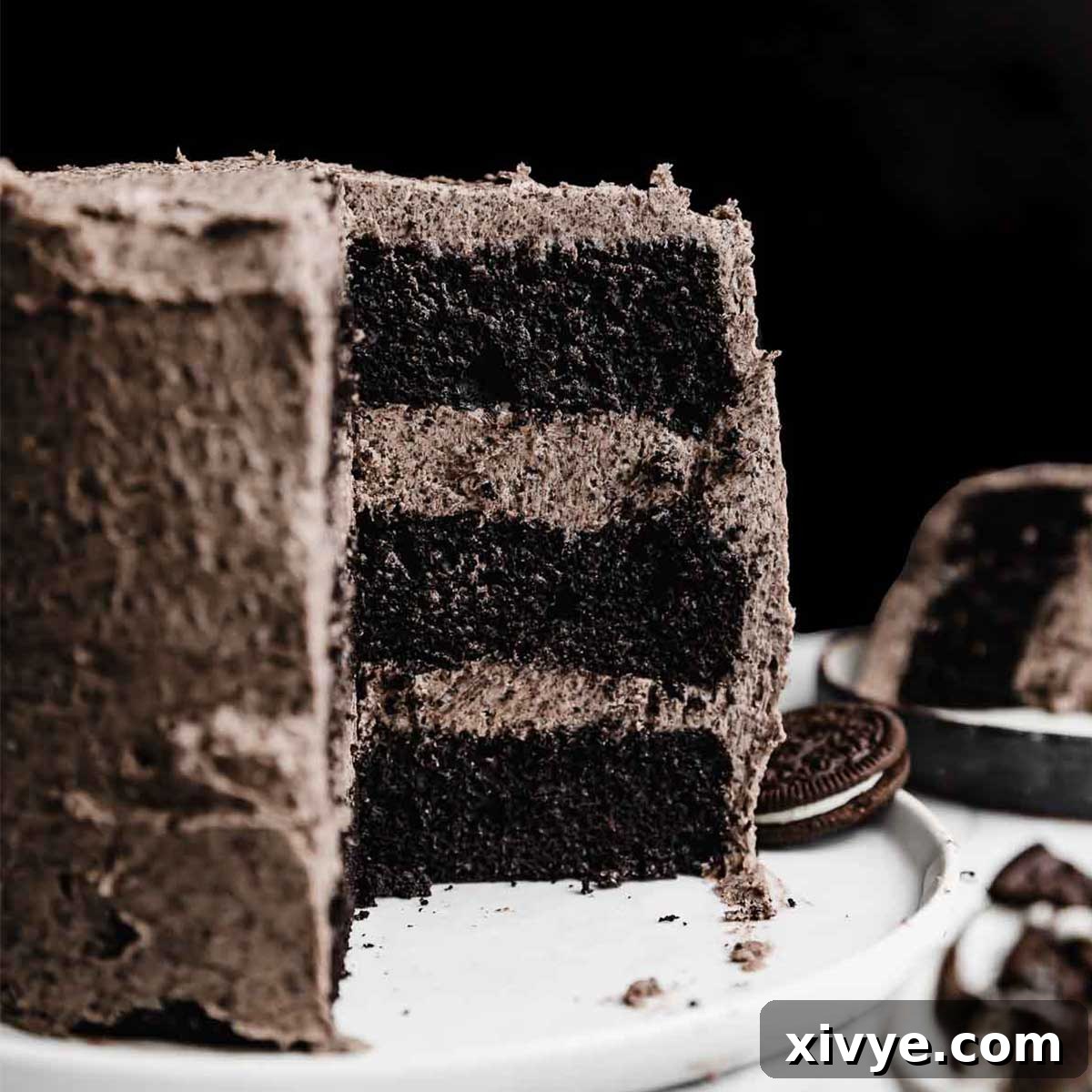 Irresistible Oreo Creations 9 A magnificent three-layer, six-inch Oreo Cake, beautifully topped with luxurious Oreo frosting, set against a dramatic black background.