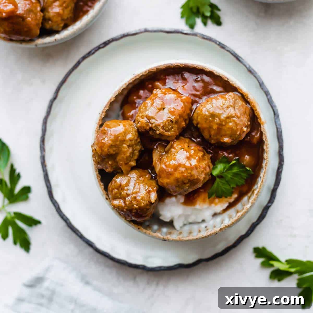 An overhead photo of easy crock pot BBQ Pineapple Meatballs, glistening in their sauce, served in a inviting bowl.