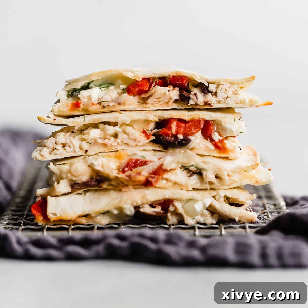 Perfectly cut Greek Quesadillas, arranged invitingly against a clean white background, showcasing their delicious fillings.