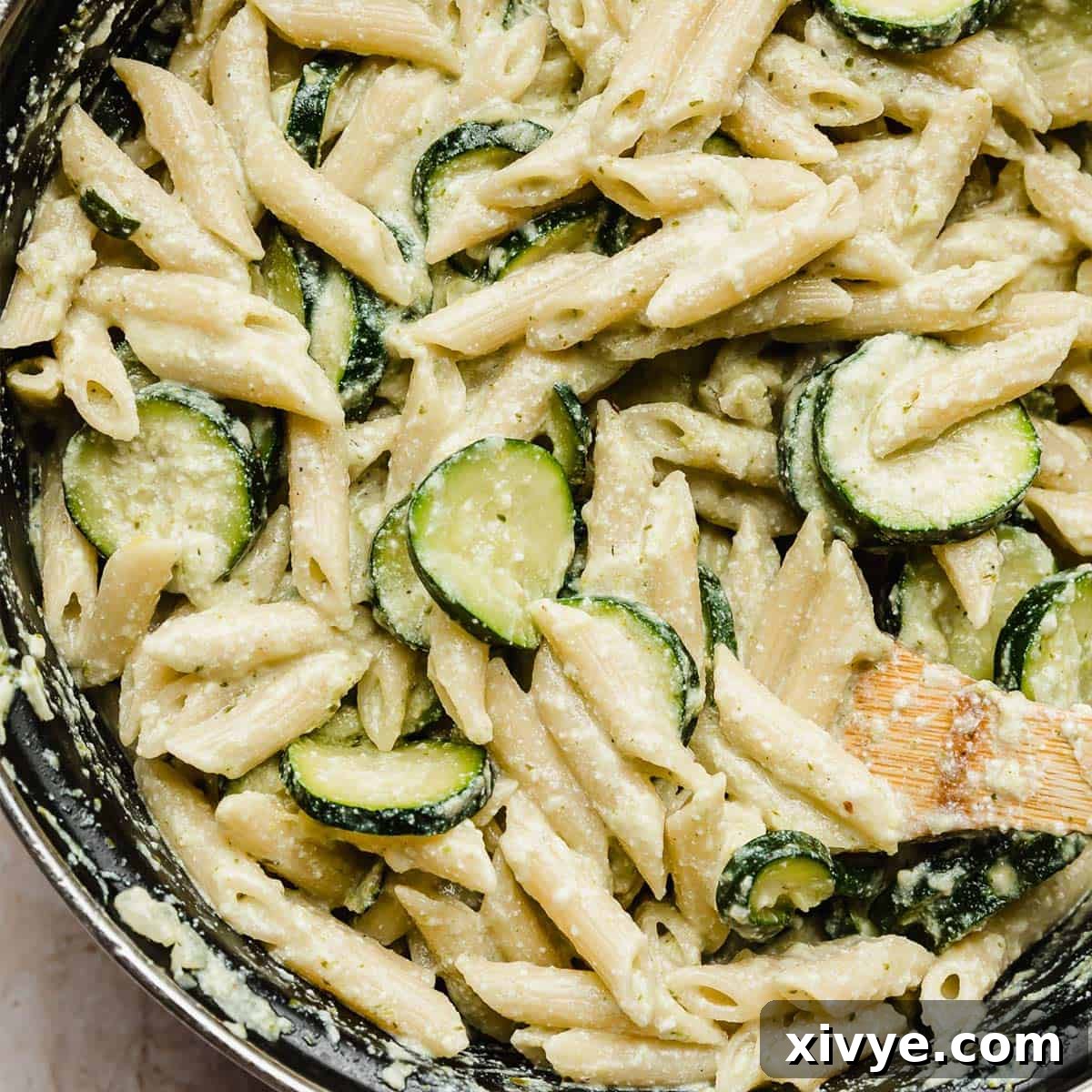 A close-up photo of delicious Pasta with Zucchini and Ricotta, simmering invitingly in a black pot.