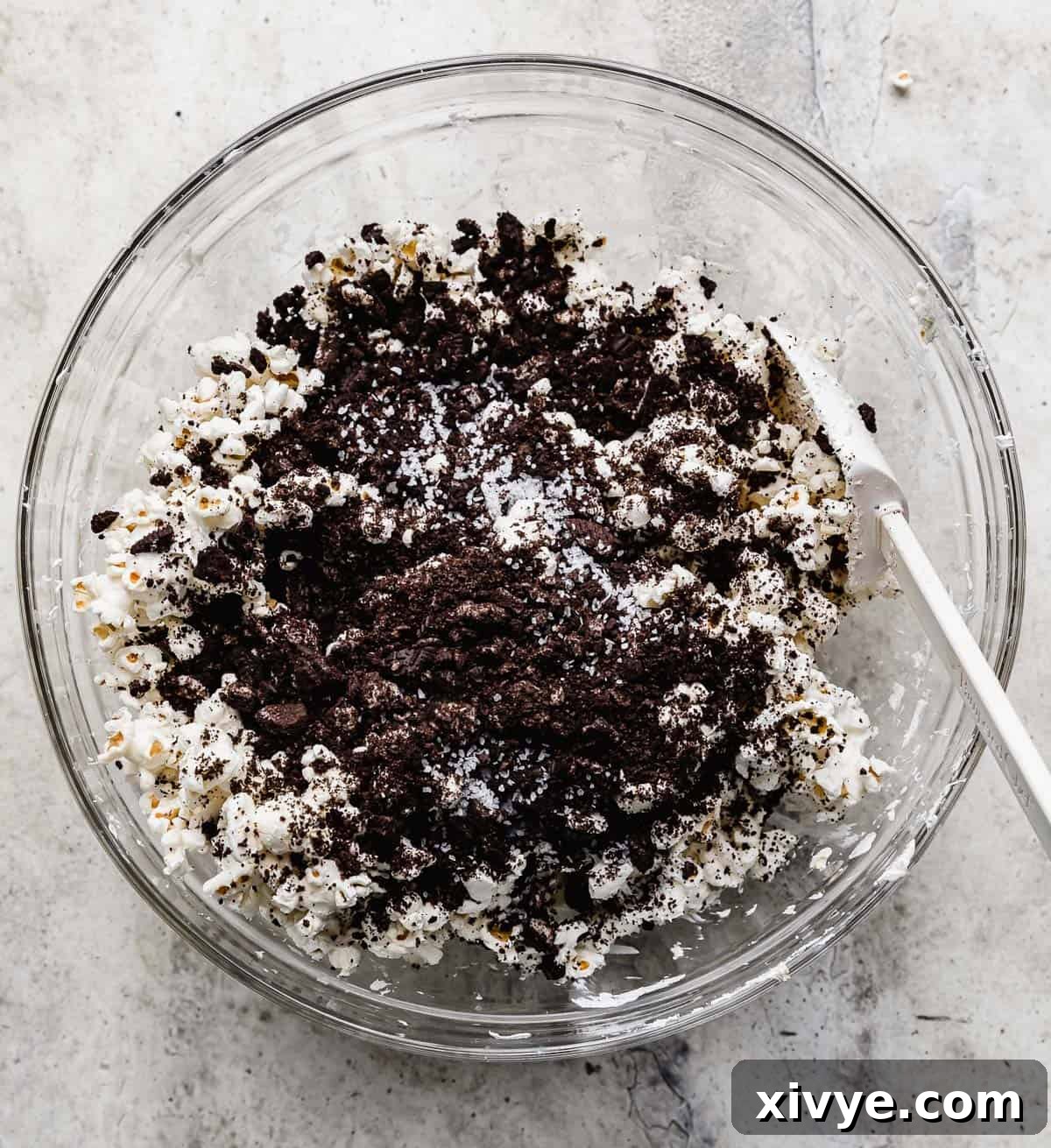 White chocolate-coated popcorn now being generously mixed with dark Oreo crumbs.