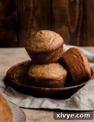 Three All Bran Muffins on a brown plate against a brown wooden background.
