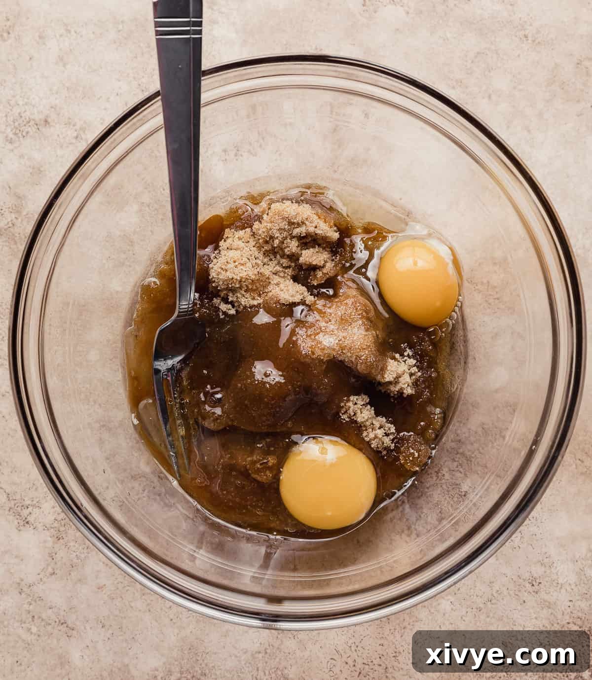 Hearty Buttermilk Bran Muffins 6 A glass bowl filled with brown sugar, two eggs, and oil for making an easy bran muffin recipe.