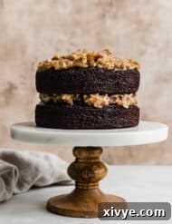 A photo of a two layer German Chocolate Cake with coconut pecan frosting between the layers.
