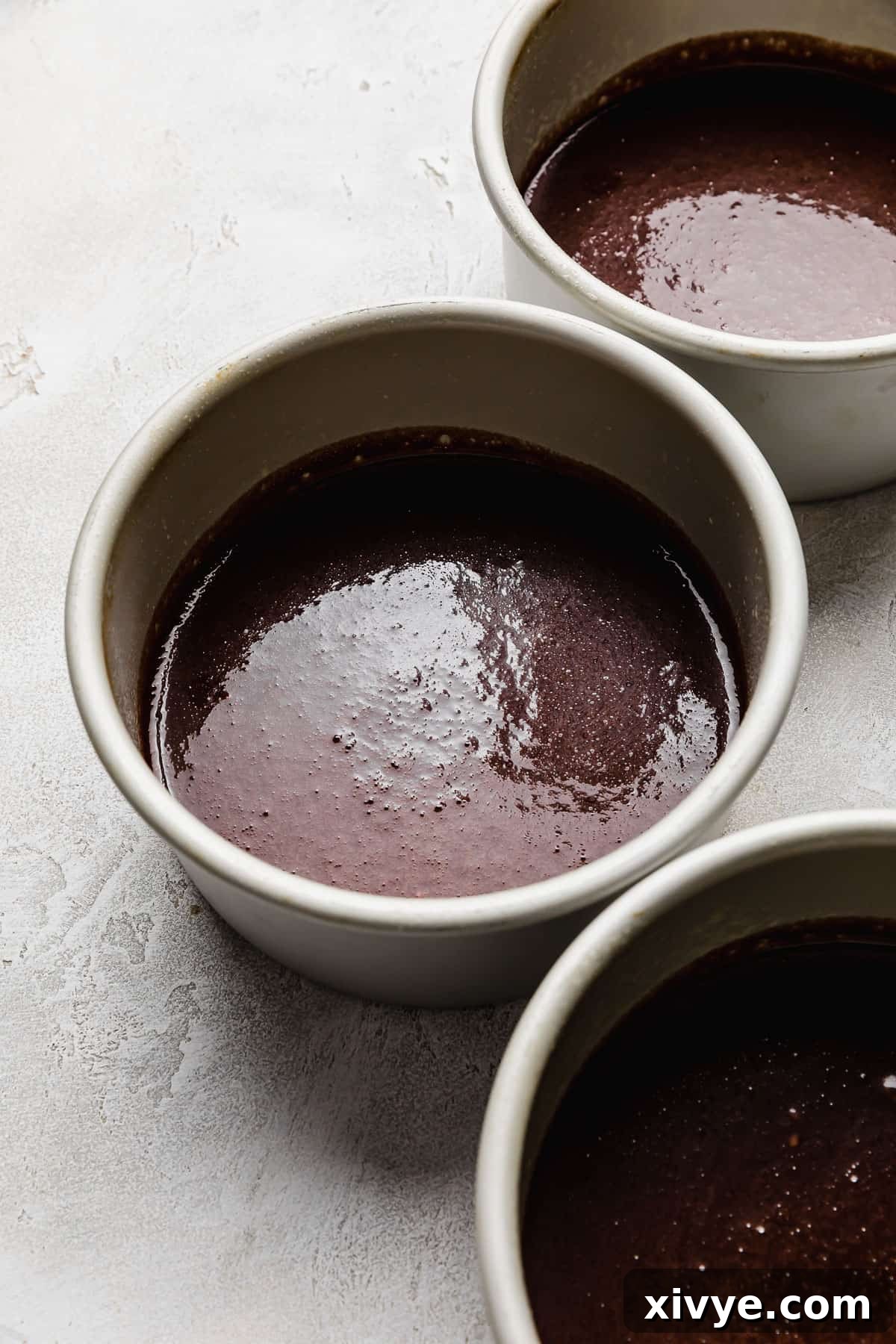 A 6-inch round cake pan filled with the dark, rich batter for a Small German Chocolate Cake, ready for baking.