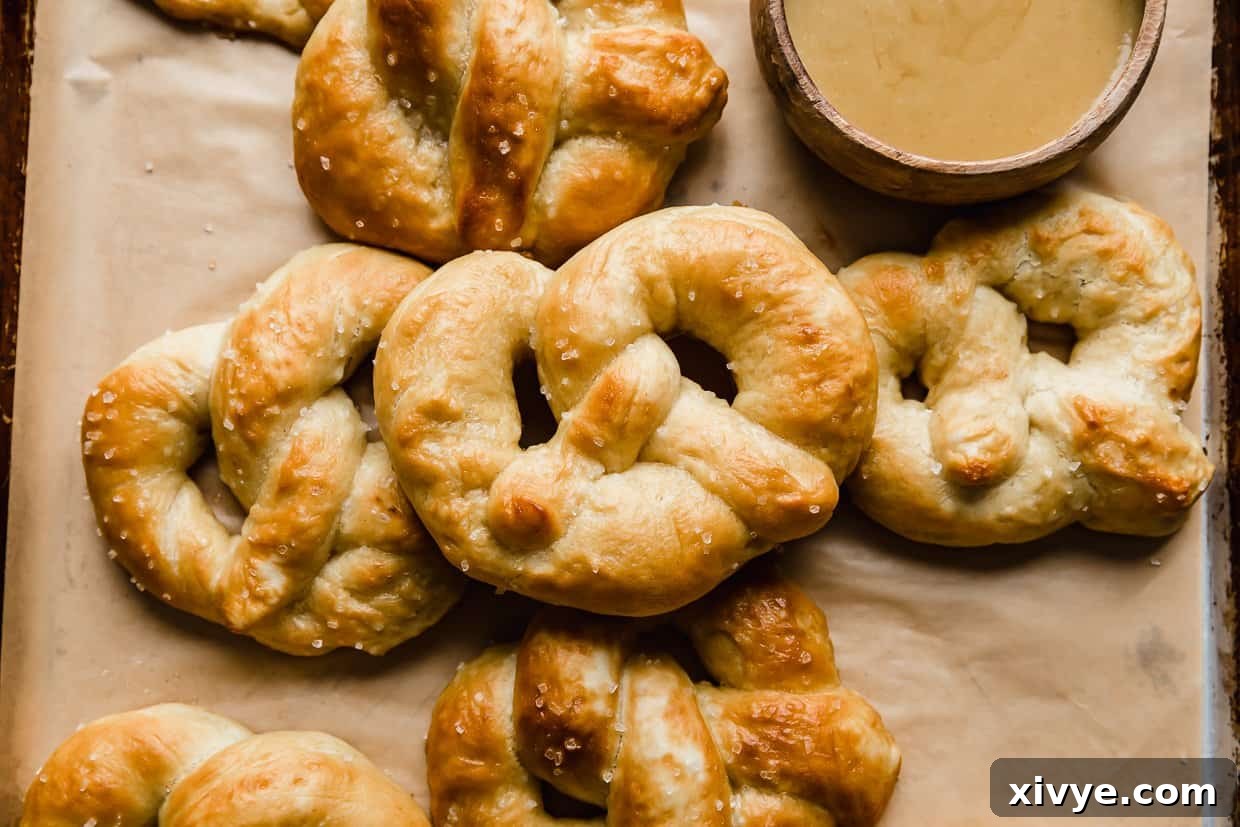 Pillowy Homemade Soft Pretzels 12 Homemade Soft Pretzels on a tan parchment paper.