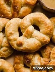 Pillowy Homemade Soft Pretzels 13 Golden baked Homemade Pretzels on a tan background.