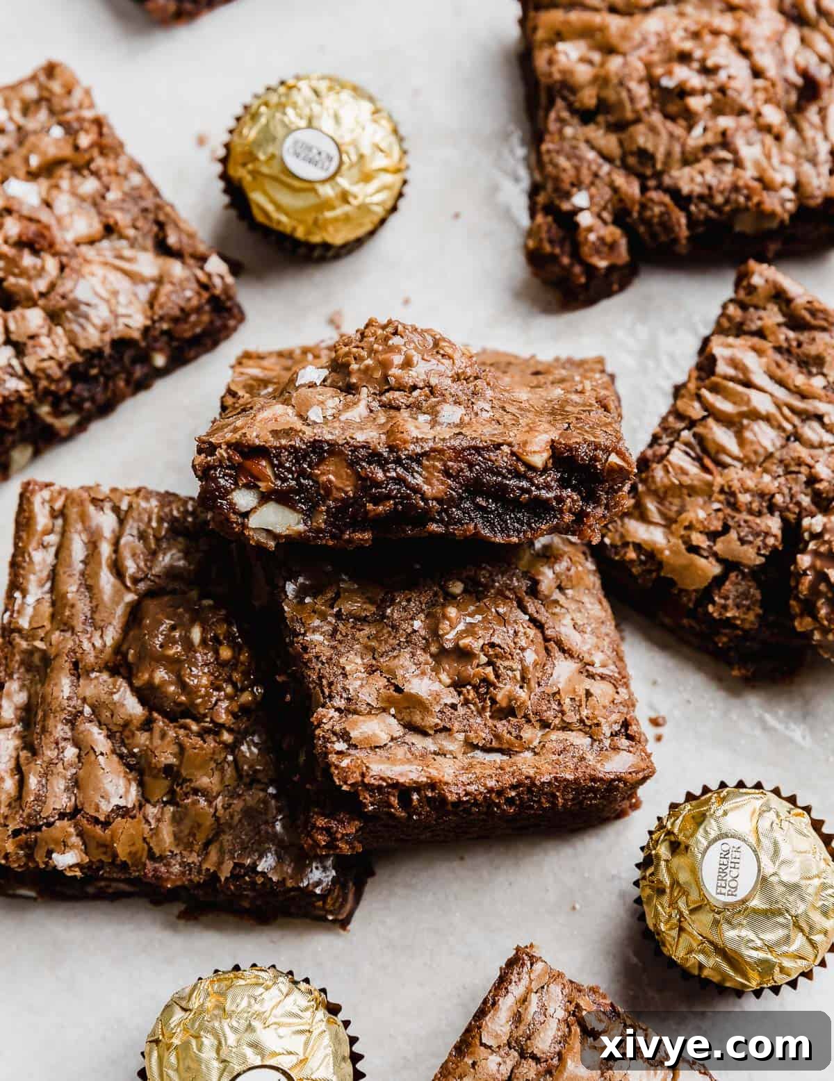 Ferrero Rocher Brownies cut into squares with Ferrero Rocher candies surrounding the brownies.