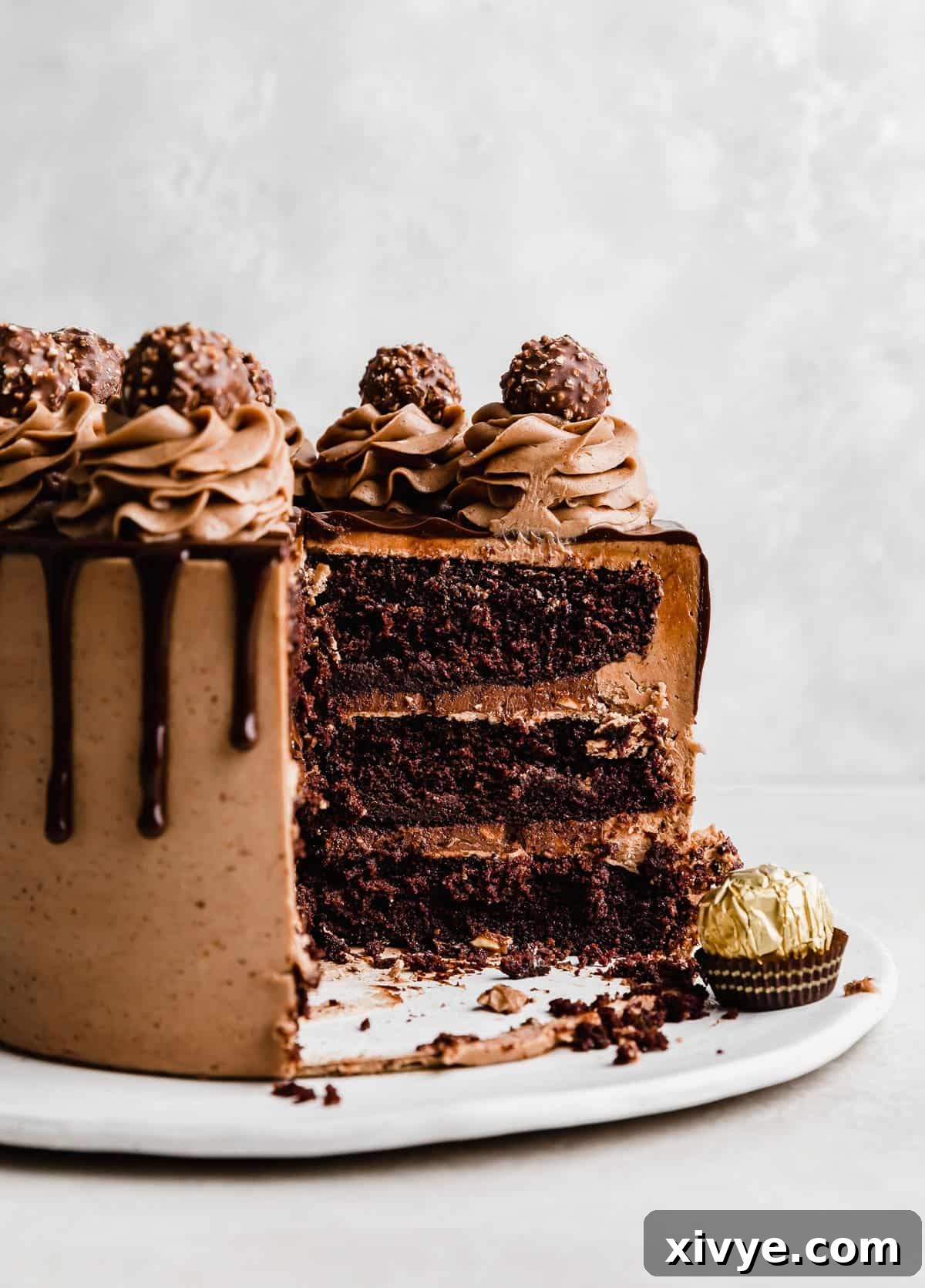 Ultimate Ferrero Rocher Indulgence 2 A three layer Ferrero Rocher Cake frosted with chocolate frosting and topped with unwrapped Ferrero Rocher candies.