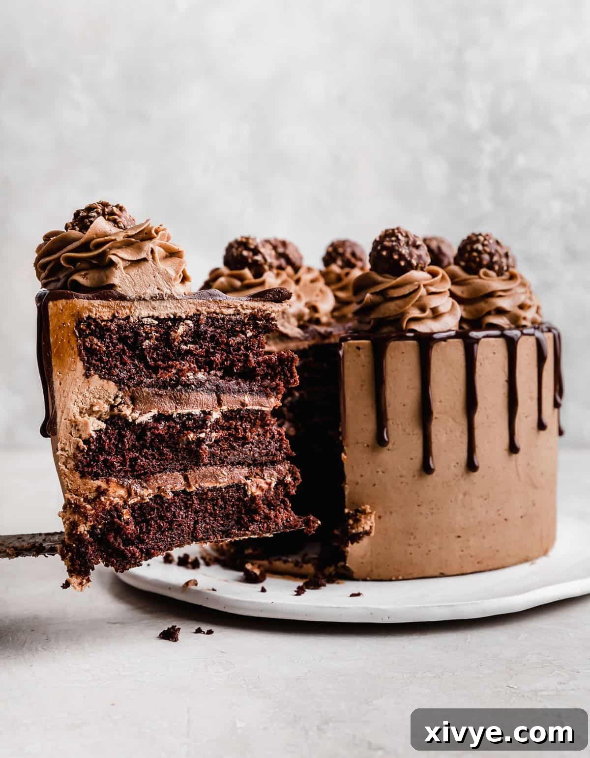 Ultimate Ferrero Rocher Indulgence 11 A slice of Ferrero Rocher Cake topped with chocolate buttercream and a chocolate drip.