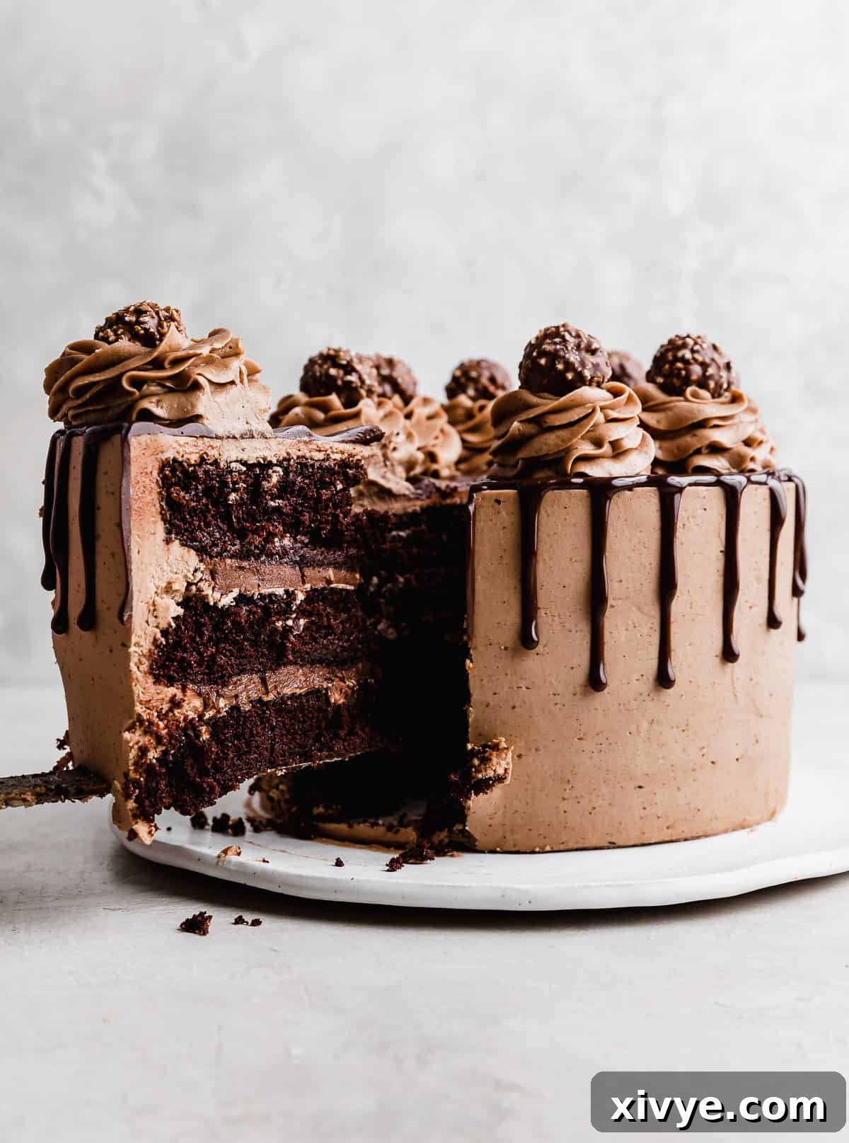 Ultimate Ferrero Rocher Indulgence 3 A slice of Ferrero Rocher Cake being pulled from the larger cake.
