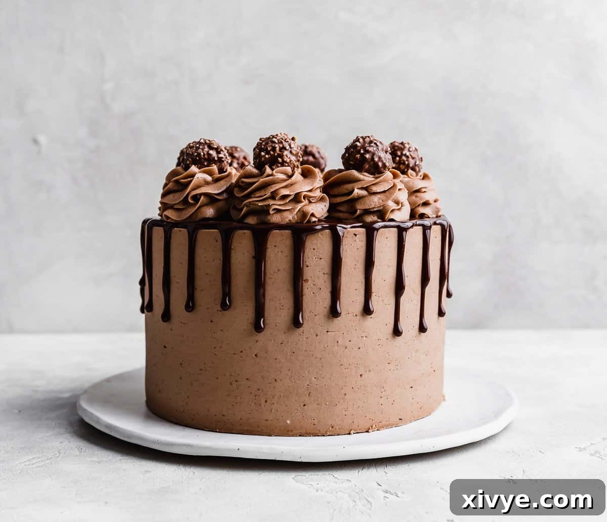 Ultimate Ferrero Rocher Indulgence 10 A Ferrero Rocher Cake topped with chocolate swirled and a chocolate drip, with Ferrero Rocher candied on the top of each swirl.