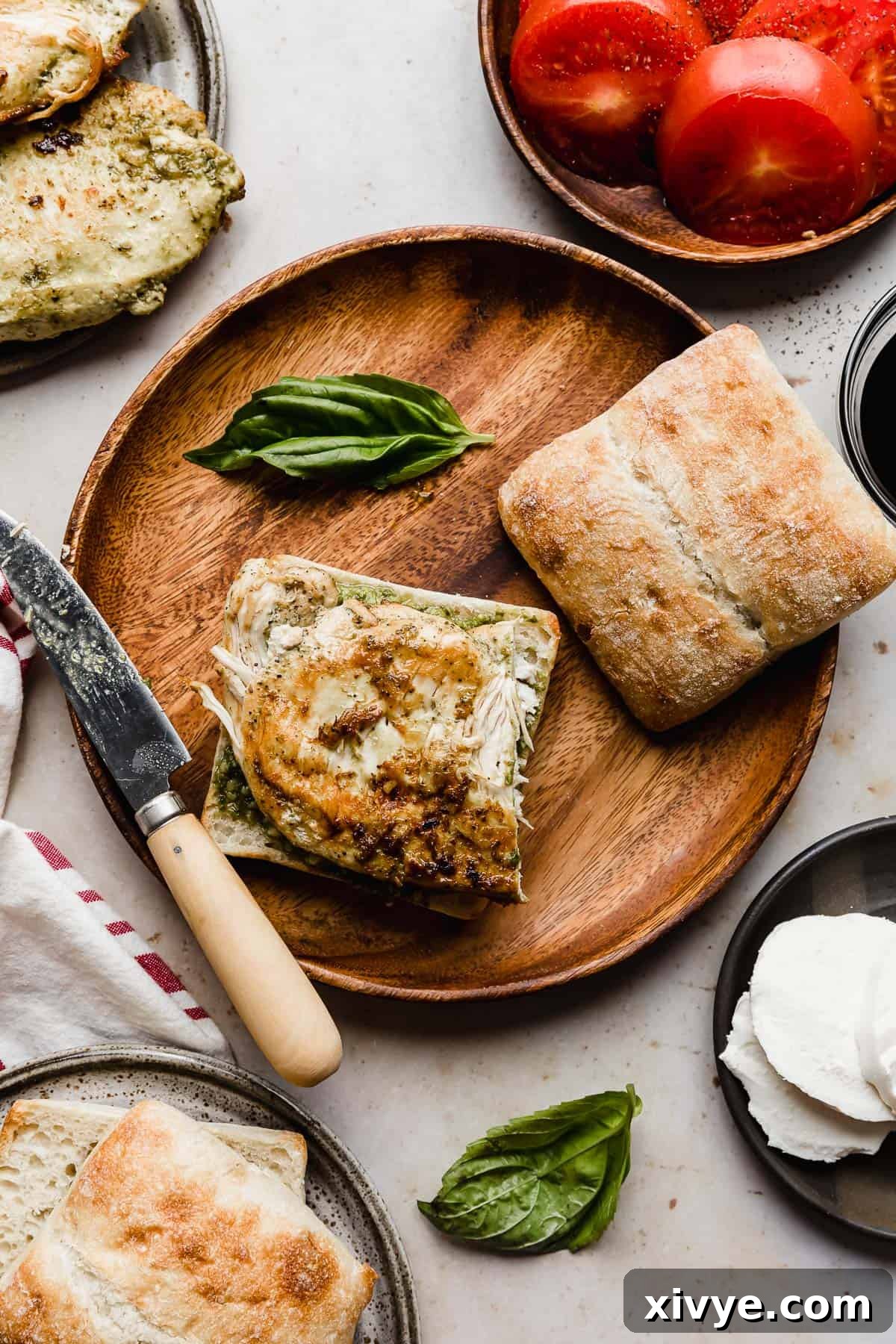 Gourmet Caprese Chicken Sandwich 5 A square ciabatta loaf with a grilled chicken breast on the bread, topped with fresh mozzarella slices.