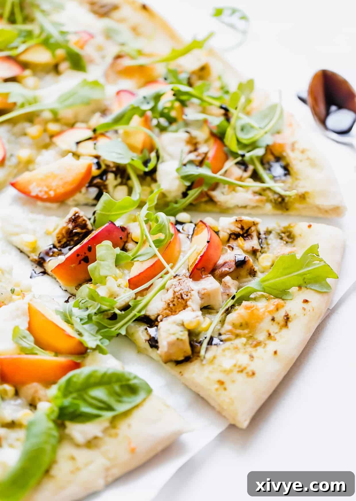 Peppery Rocket Pesto Pizza 8 Slice of pizza topped with diced chicken, corn, nectarines, ricotta, and arugula.