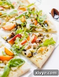 Peppery Rocket Pesto Pizza 9 Slice of pizza topped with diced chicken, corn, nectarines, ricotta, and arugula.