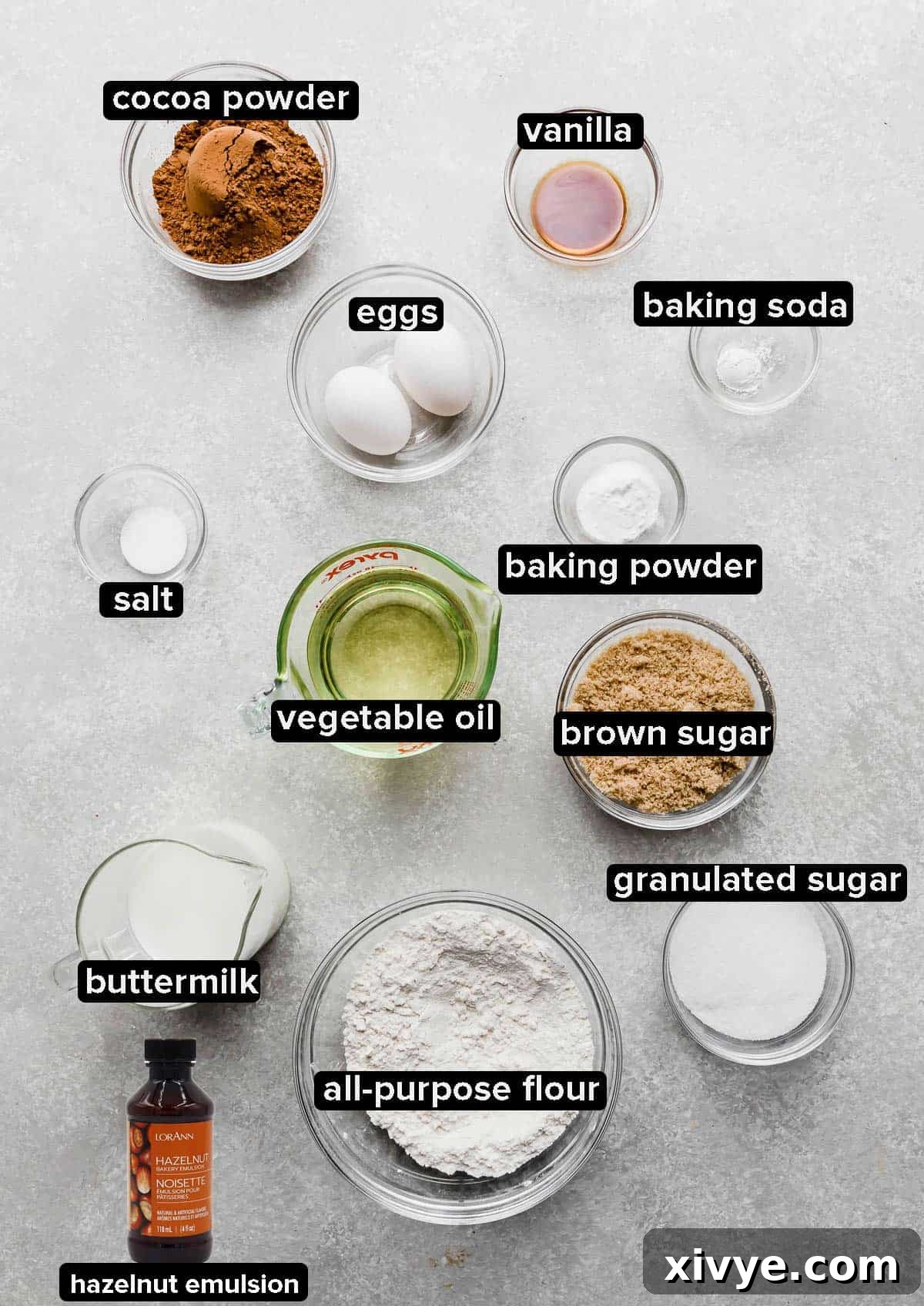 Ferrero Rocher Cupcake ingredients portioned into glass bowls on a gray background. 