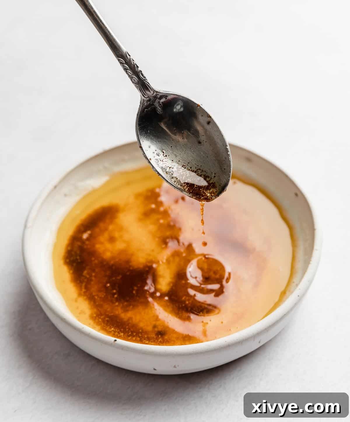 The Secret to Nutty Butter 2 A spoon scooping up browned butter from a white bowl.