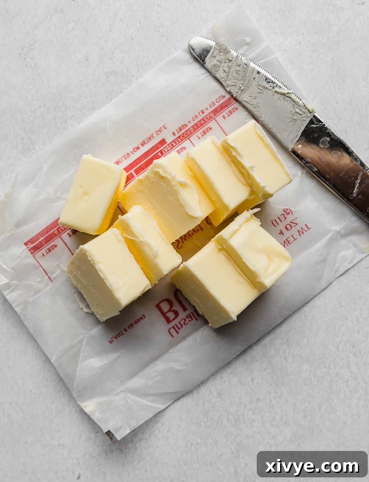 The Secret to Nutty Butter 4 A cube of butter cut into tablespoon sized pieces on a white background.