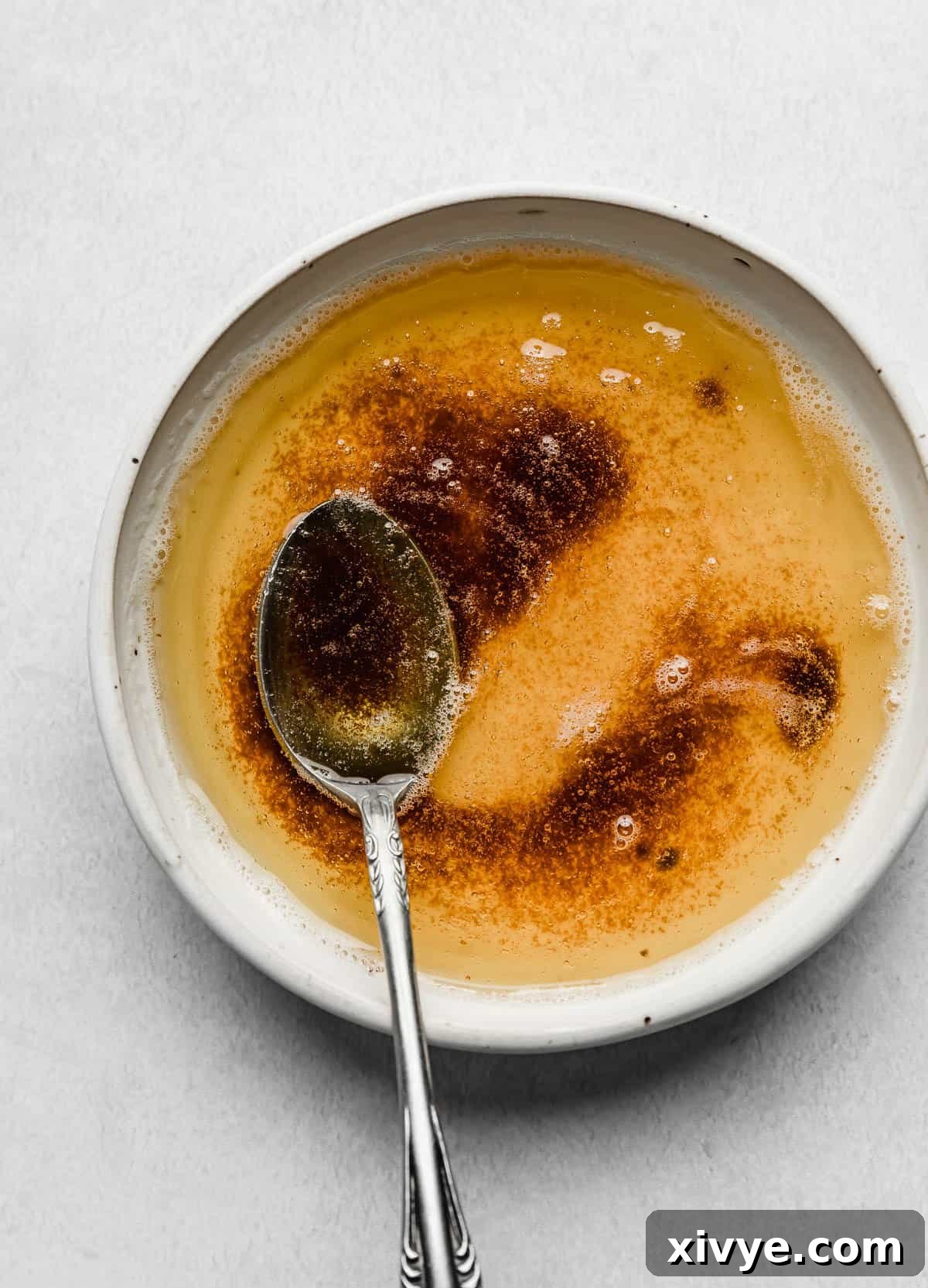 The Secret to Nutty Butter 9 A white bowl with browned butter and a spoon in it.