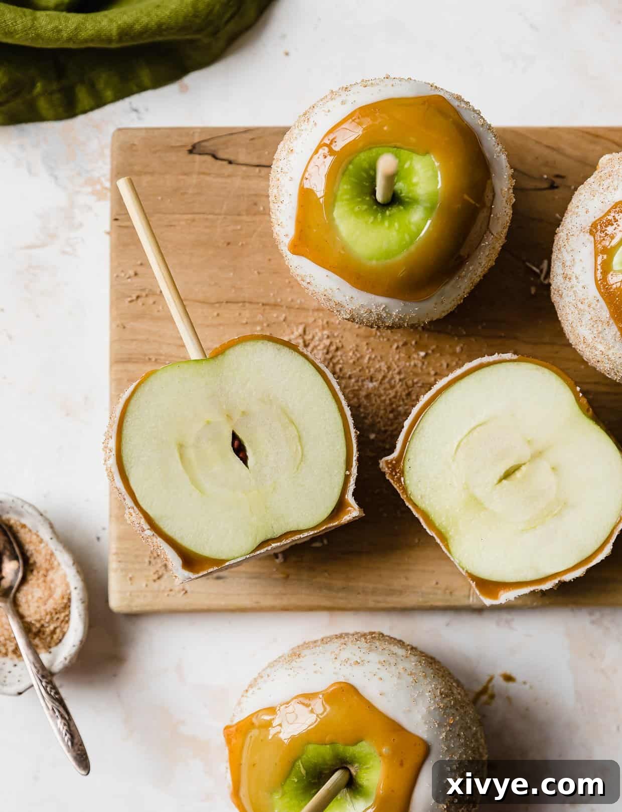 Caramel Apple Pie Fusion 13 Overhead photo of Rocky Mountain Chocolate Factory Apple Pie Caramel Apples on a wooden cutting board on a white background.
