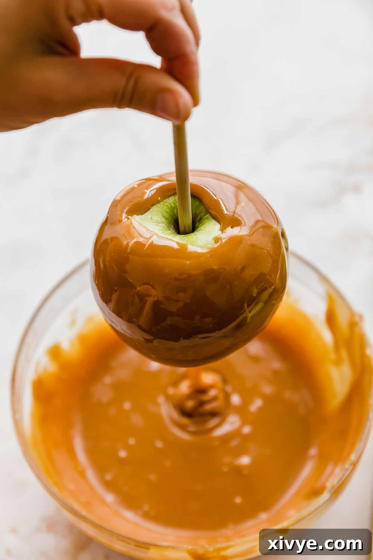 Caramel Apple Pie Fusion 8 A green apple on a stick covered in caramel.