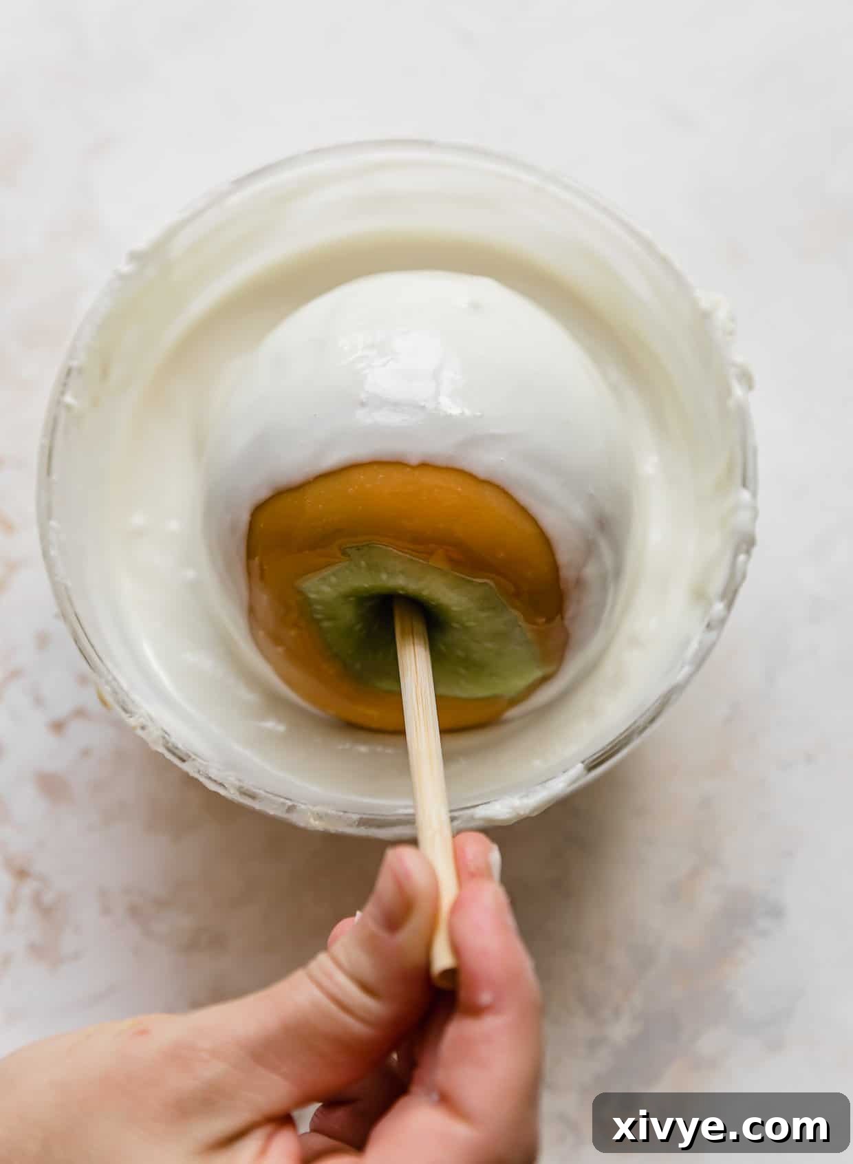 Caramel Apple Pie Fusion 9 A caramel coated apple being dipped in a bowl filled with melted almond bark (or white chocolate).