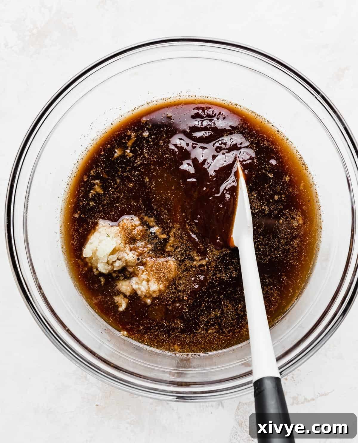 A rich, dark brown barbecue sauce mixed with Coca Cola, ready for coating baby back pork ribs.