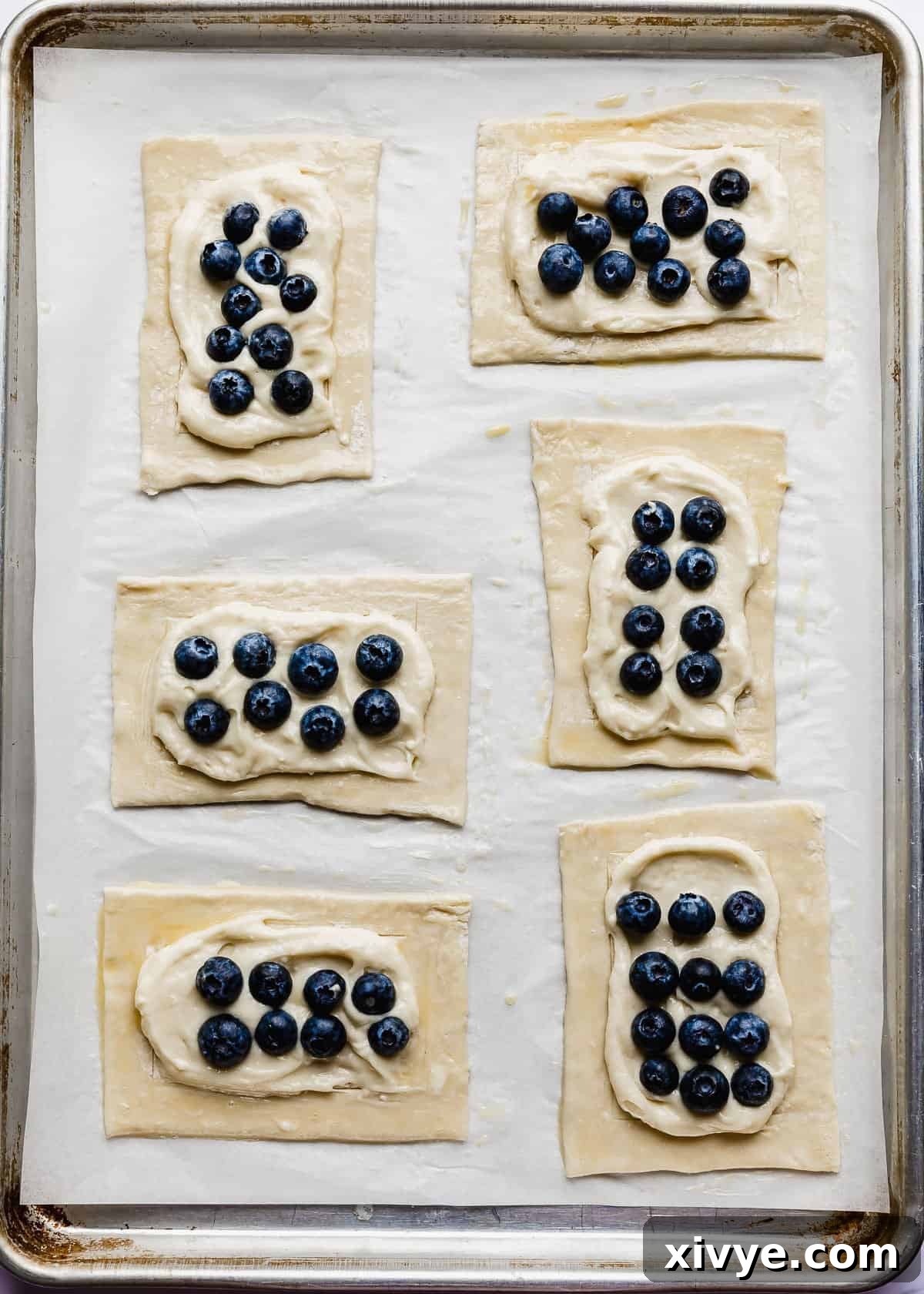 Flaky Blueberry Dream 7 Fresh blueberries on top of a cream cheese mixture on raw puff pastry squares.