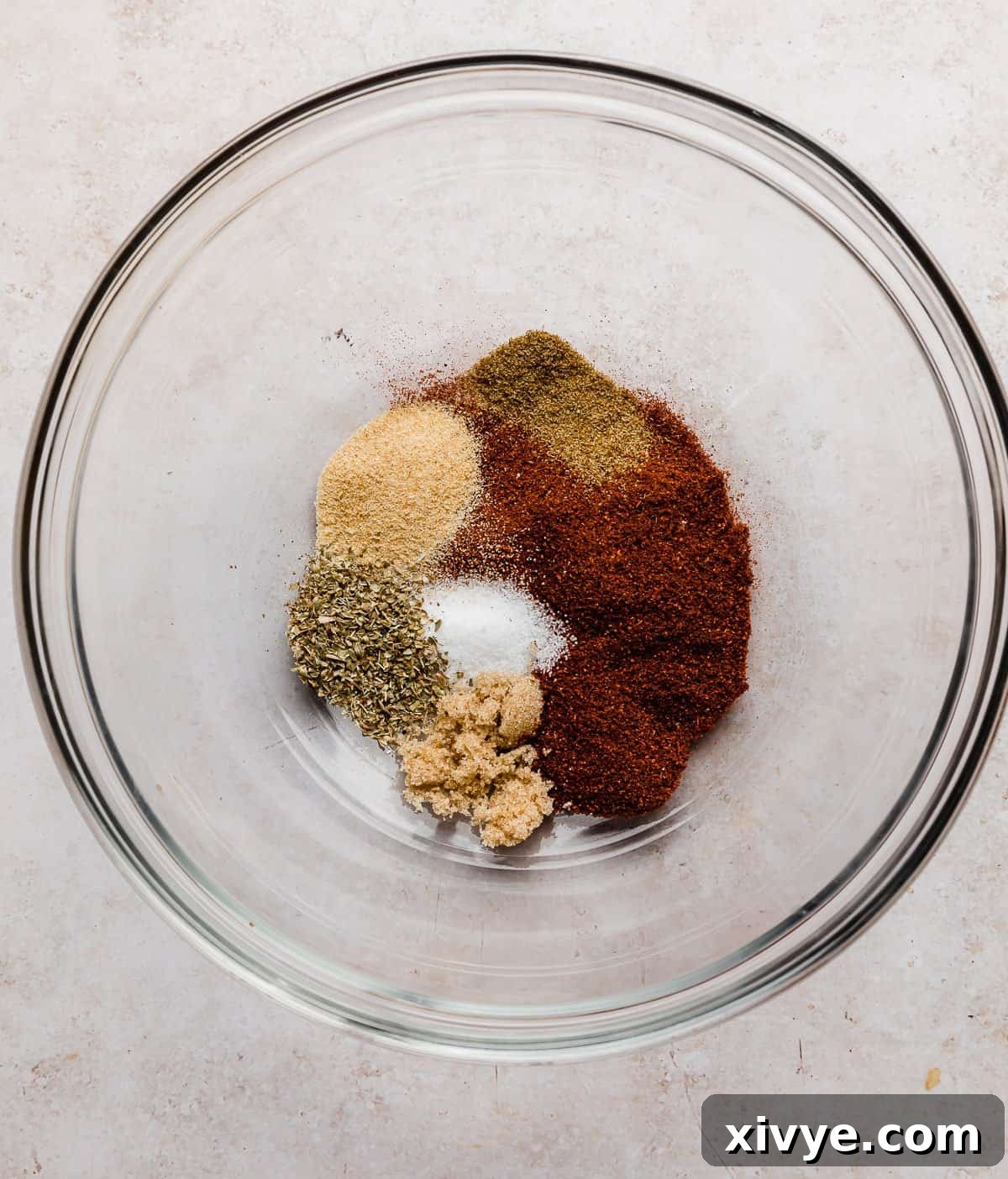 A glass bowl filled with the vibrant spice mixture used for Blackened Shrimp.