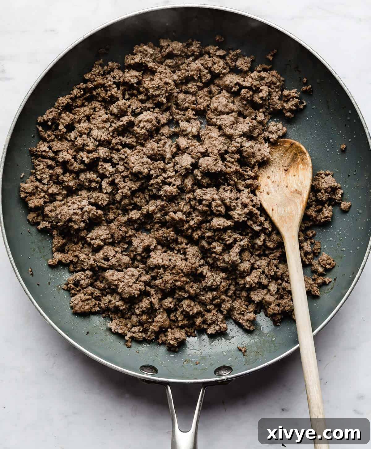 Ultimate Doritos Taco Salad 5 Cooked ground beef in a grey skillet, ready for the next step in making a mouth-watering Doritos Taco Salad with Catalina dressing.