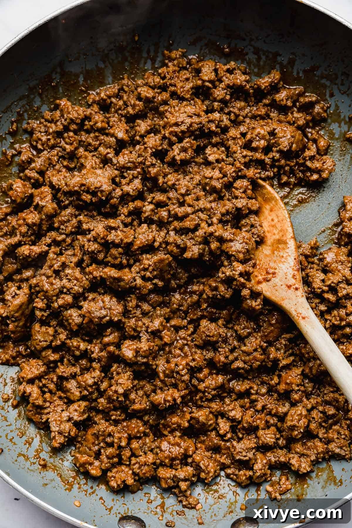 Ultimate Doritos Taco Salad 6 Ground beef perfectly mixed with taco seasoning, simmering in a grey skillet, forming a delicious base for Doritos Taco Salad.