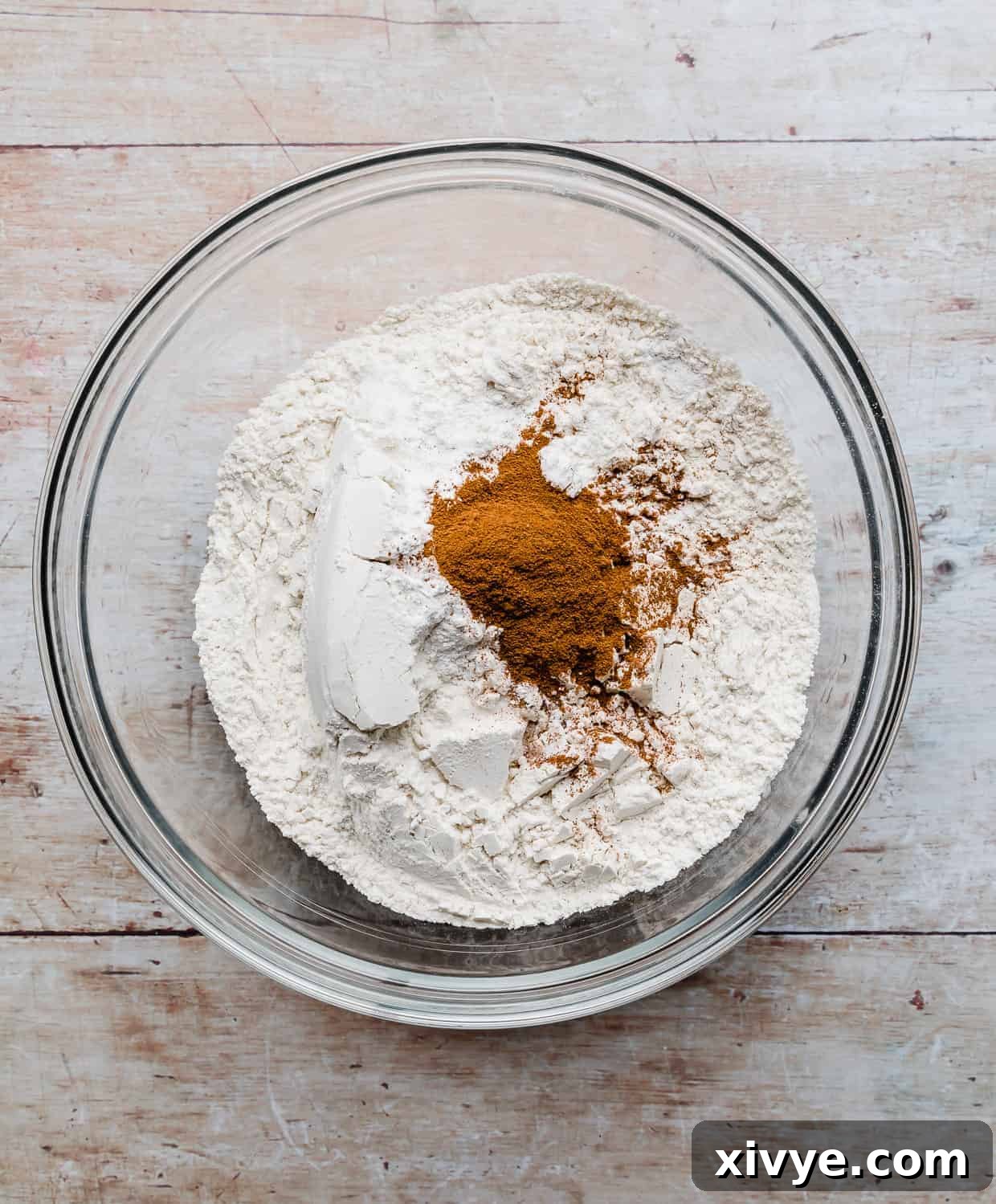 The dry ingredients used to make zucchini bread, in a glass bowl.